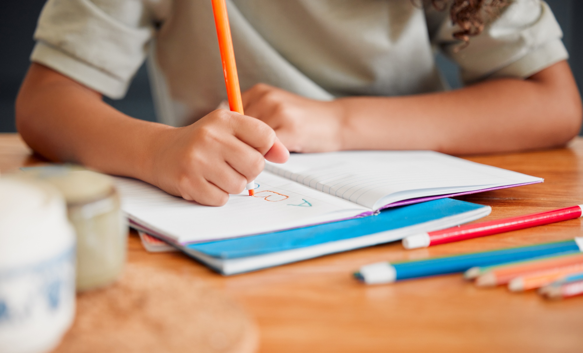 Child coloring, drawing and doing art activity in book in home living room while having fun, enjoyi