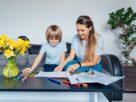 Mother and son drawing with color pencils and markers in the living room. Child creativity concept.