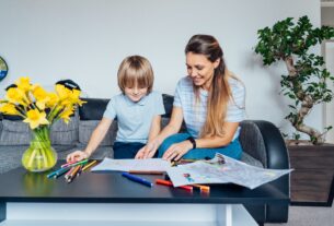 Mother and son drawing with color pencils and markers in the living room. Child creativity concept.