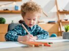 selective focus of kid drawing at desk